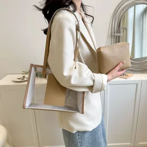 Detail of transparent PVC tote bag with tan leather handles and matching inner pouch