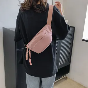 Detail van roze nylon crossbodytas met verstelbare brede riem gedragen op een model