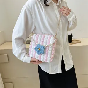 Detailed view of the pink bubble fabric bag with a blue floral accent and pearl chain handle