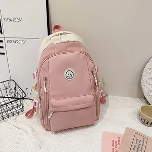 Dettaglio dello zaino in tela rosa e beige con toppa a ricamo con faccina sorridente