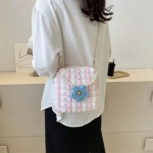 Detail of pink and white striped bubble crossbody bag with pearl handle and blue flower charm