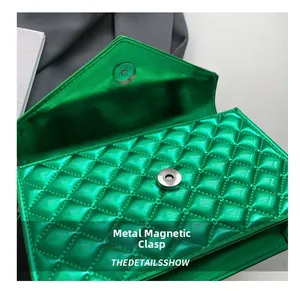Détail du fermoir magnétique argenté sur un sac à bandoulière vert matelassé