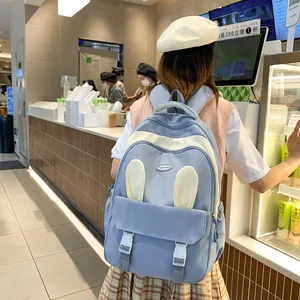 Detail of light blue backpack featuring cute bunny ears design and fashion logo
