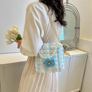 Blue striped popcorn fabric crossbody bag with pearl handle and floral charm