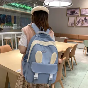 Detail of light blue school backpack with cute bunny ears and multi-pocket design