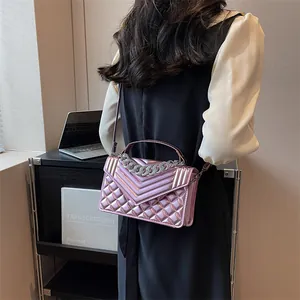 Détail du sac à main matelassé avec grosse chaîne en métal et texture brillante