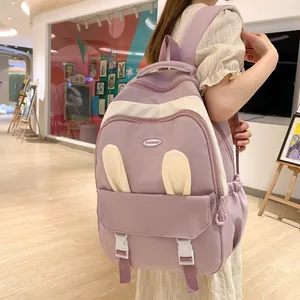 Detail of purple student backpack featuring cute bunny ears and fashion logo on the front