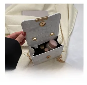 Detail view of the open white crocodile pattern bag showing inner capacity for cosmetics