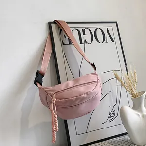 Detailopname van roze nylon crossbodytas met geweven touwrits en stevige plastic gesp