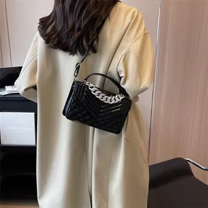 Détail du sac bandoulière matelassé noir avec chaîne en strass argentée et vernis