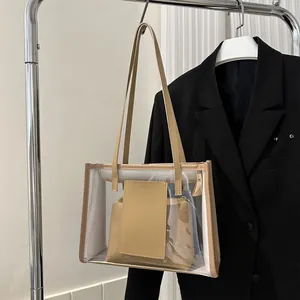 Detail of transparent PVC tote bag with leather straps and inner pouch on a hanger