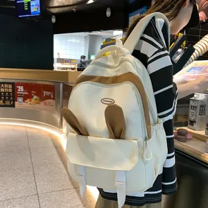 Lifestyle side view of casual backpack with cute brown rabbit ears and fashion label