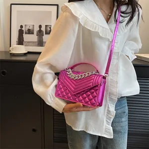 Détail d'un sac bandoulière rose métallisé avec matelassage en V et chaîne argentée