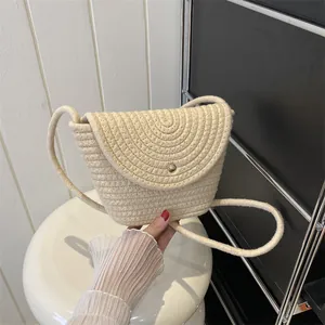 Close-up of beige woven bucket bag with spiral texture and gold button fastener