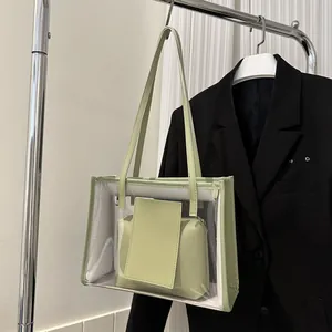 Detail of transparent PVC tote bag featuring light green faux leather trim and inner pouch
