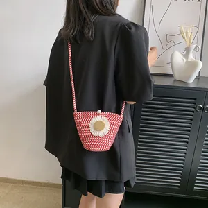 Détail du sac en paille à carreaux rouges avec marguerite et bouton en perle