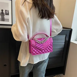 Vue détaillée du sac matelassé rose vif avec une poignée en chaîne de strass étincelants