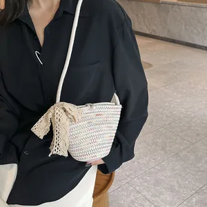 Détail du sac bandoulière tissé coloré avec boucle perle et décoration nœud en dentelle