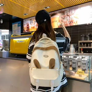 Detail of cute cream backpack with 3D bunny ears and 'FASHION' embroidery in a cafe