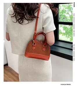 Sac à main marron texturé avec garnitures dorées, vue latérale élégante sur modèle