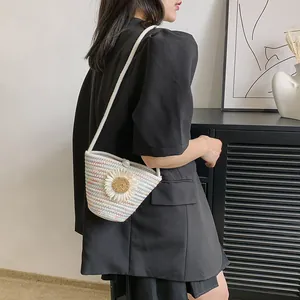 Détail du sac tissé à rayures colorées avec fleur de marguerite blanche et fermoir perle