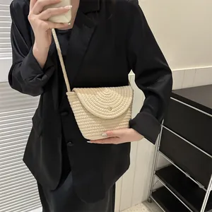 Minimalist beige woven crossbody bucket bag with round gold buckle and slim strap