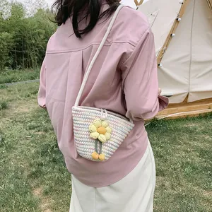 Detailed view of hand-woven macaron colorful stripe bucket bag with a cute floral charm