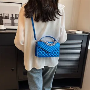 Vue détaillée du sac bandoulière matelassé bleu électrique avec poignée en chaîne