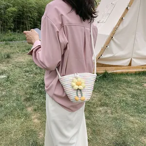 Outdoor look of a woven bucket bag with colorful stripes and crochet floral detail