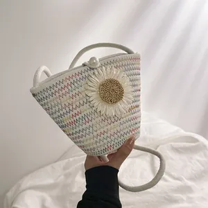 Détail du sac seau en paille avec motif zigzag coloré, marguerite et fermoir en perle