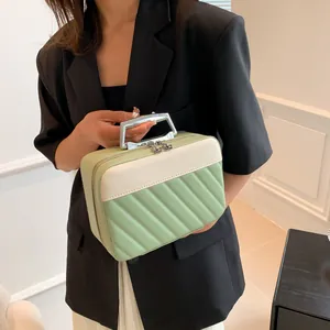 Close-up of quilted mint green cosmetic bag with silver handle and flower zippers