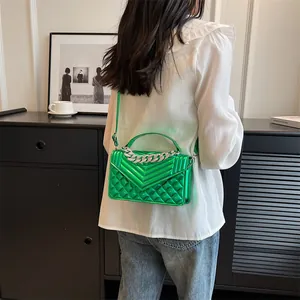 Détail d'un sac bandoulière vert métallisé avec chaîne argentée et motifs matelassés