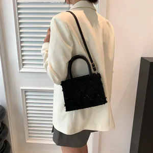 Women's black quilted tote bag with fringe texture and detachable strap for crossbody use