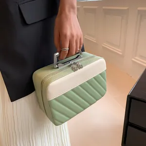 Detail of green quilted vanity bag featuring silver metal handle and petal shaped zipper