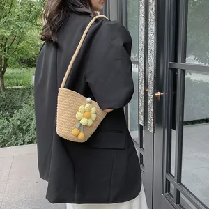 Fashionable woven bucket bag with large yellow daisy and elegant pearl closure
