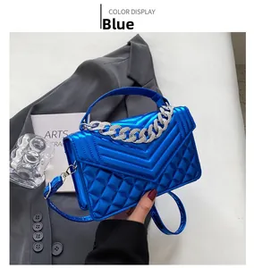 Détail du sac à main laqué bleu matelassé avec chaîne argentée et fini brillant