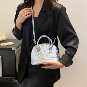 Détail du sac coquillage argenté montrant la texture tressée et le fini métallisé