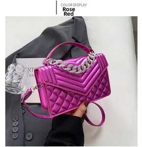 Détail du sac à main rose fuchsia avec surpiqûres en V et décoration de chaîne argentée