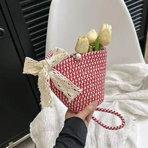 Détail du sac seau tressé avec nœud en dentelle et fermoir en perle fine