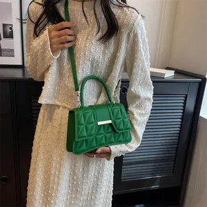 Detailed view of green quilted leather texture and golden metal buckle closure