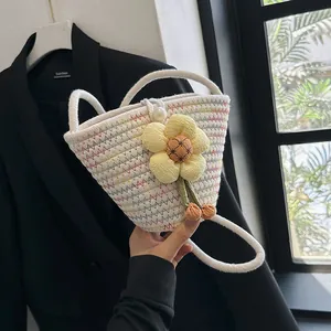 Detail of hand-woven bucket bag with white rope texture and large yellow flower charm