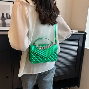 Sac bandoulière carré vert métallisé matelassé avec chaîne en argent sur modèle