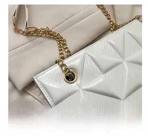 Gros plan sur un sac blanc matelassé géométrique avec des détails métalliques dorés