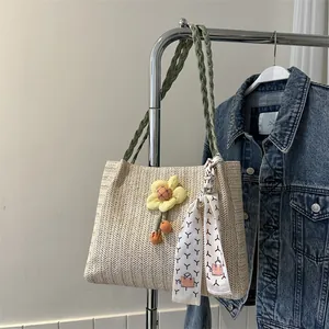 Détail du sac seau en paille tressée avec tournesol et foulard en soie chic