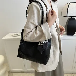 Detail view of black houndstooth tote bag with a polka dot scarf on a model's shoulder