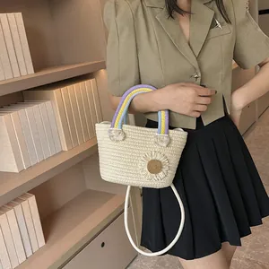Détail du sac seau tissé avec fleur marguerite 3D et poignée arc-en-ciel tressée