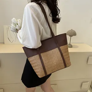 Detail einer großen braunen Leder und Stroh Patchwork Tote Bag an einem Modell