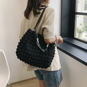 Large black bubble textured tote bag with pearl chain detail for commuter women