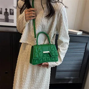 Grass green crossbody bag with geometric embossing and adjustable strap on a model