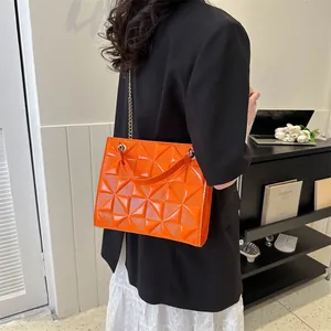 Sac bandoulière en cuir verni orange vif avec relief géométrique et chaîne dorée chic